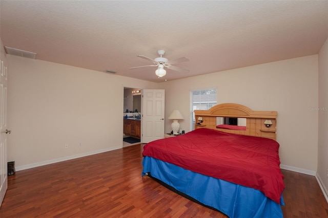 bedroom with ceiling fan, connected bathroom, and dark wood-type flooring