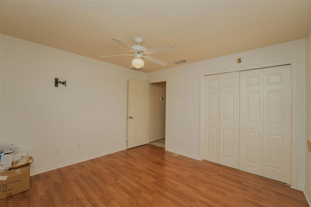 unfurnished bedroom featuring ceiling fan, light hardwood / wood-style flooring, and a closet