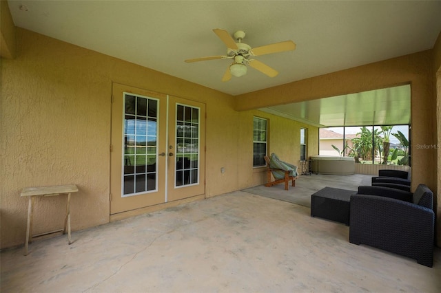 unfurnished sunroom featuring ceiling fan and french doors