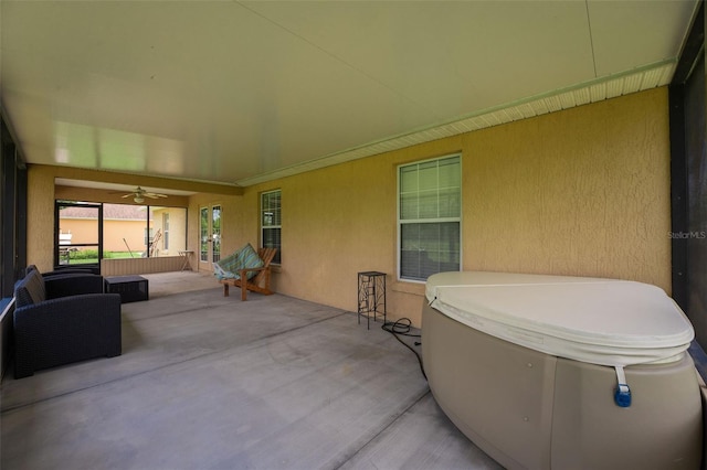 view of patio with ceiling fan and a hot tub