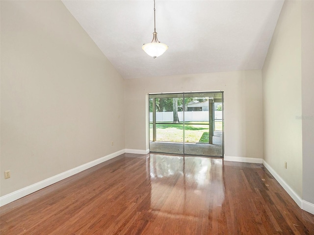 empty room with vaulted ceiling and dark hardwood / wood-style flooring