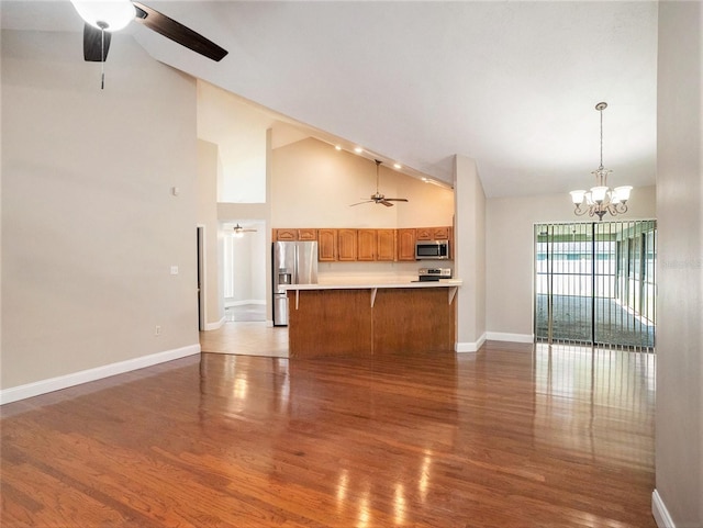 unfurnished living room featuring light wood-type flooring, ceiling fan with notable chandelier, and high vaulted ceiling