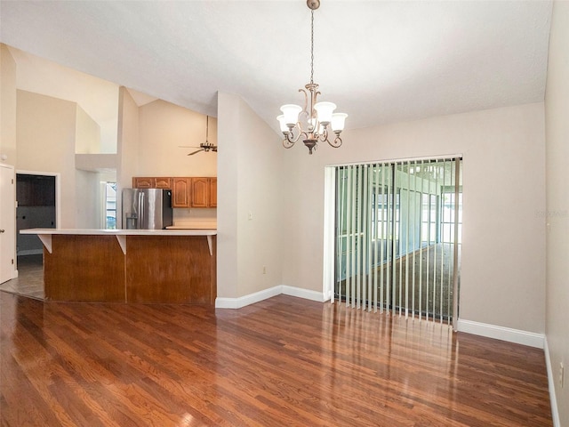 kitchen featuring a healthy amount of sunlight, stainless steel refrigerator with ice dispenser, high vaulted ceiling, hardwood / wood-style floors, and a breakfast bar area