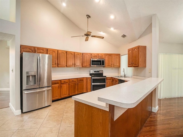 kitchen with ceiling fan, light hardwood / wood-style flooring, high vaulted ceiling, appliances with stainless steel finishes, and sink