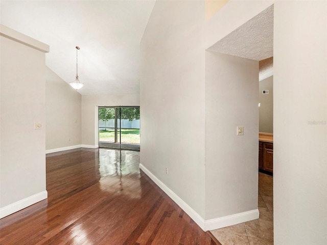 unfurnished room featuring lofted ceiling and wood-type flooring