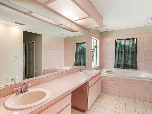 bathroom with tiled bath, tile patterned flooring, and vanity