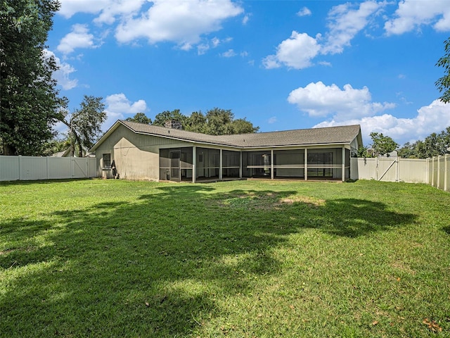 back of property featuring a sunroom and a yard