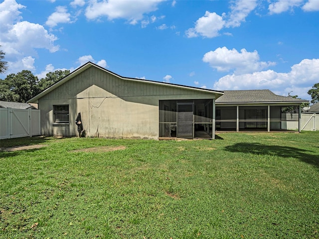 rear view of property with a lawn and a sunroom