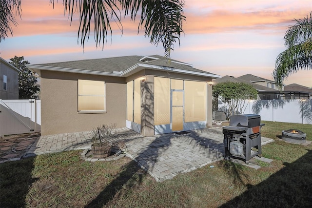 7720 Rathdown Ln, Wesley Chapel, FL 33545 - view of front of house featuring a fire pit, a patio area, stucco siding, and roof with shingles