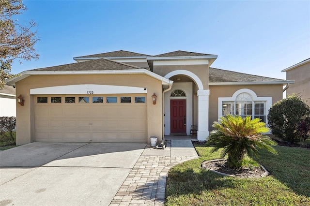 7720 Rathdown Ln, Wesley Chapel, FL 33545 - view of front facade featuring stucco siding, an attached garage, driveway, and roof with shingles