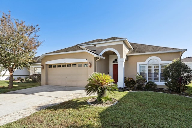 7720 Rathdown Ln, Wesley Chapel, FL 33545 - view of front of house with a garage, a front yard, driveway, stucco siding, and roof with shingles