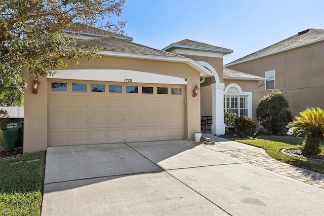 7720 Rathdown Ln, Wesley Chapel, FL 33545 - view of front of property with concrete driveway, an attached garage, stucco siding, and roof with shingles