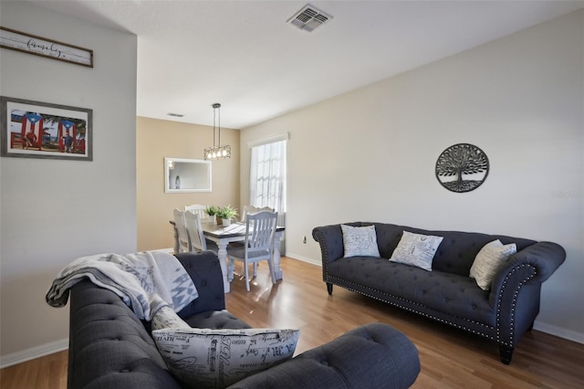 living room with hardwood / wood-style flooring and a chandelier