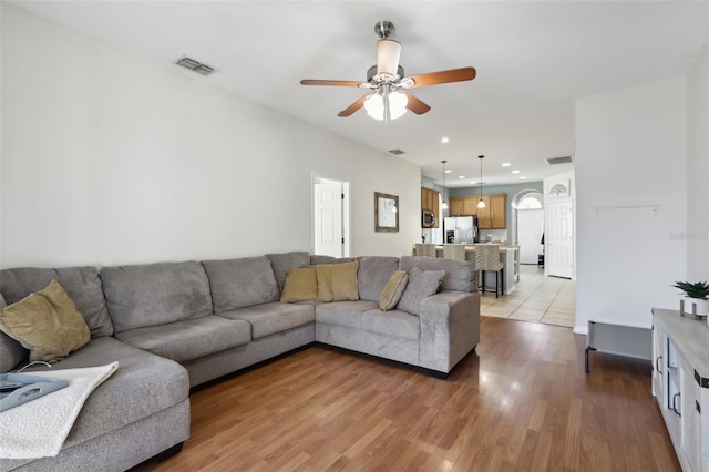 living room with ceiling fan and light hardwood / wood-style flooring