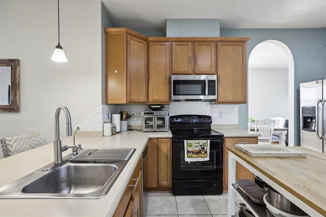 7720 Rathdown Ln, Wesley Chapel, FL 33545 - kitchen featuring appliances with stainless steel finishes, brown cabinetry, light countertops, and light tile patterned floors