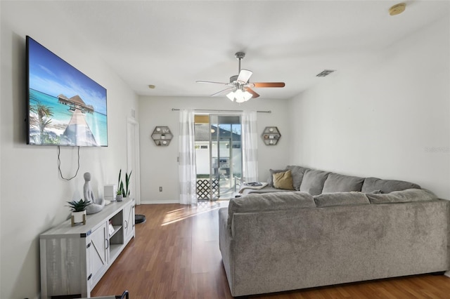 living room featuring ceiling fan and dark hardwood / wood-style floors