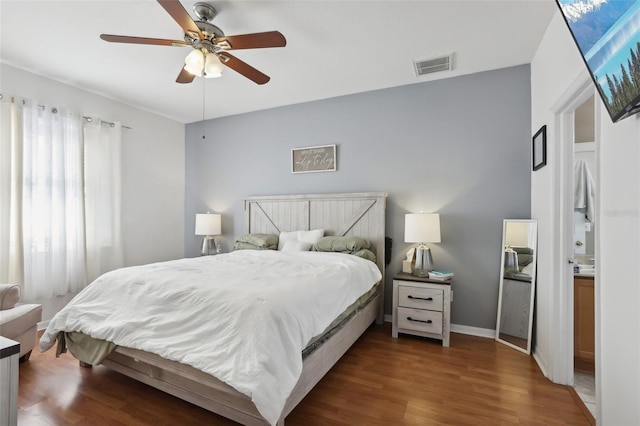 bedroom featuring connected bathroom, dark hardwood / wood-style floors, and ceiling fan