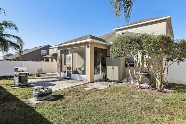 7720 Rathdown Ln, Wesley Chapel, FL 33545 - rear view of property with a sunroom, a fenced backyard, a fire pit, and a patio