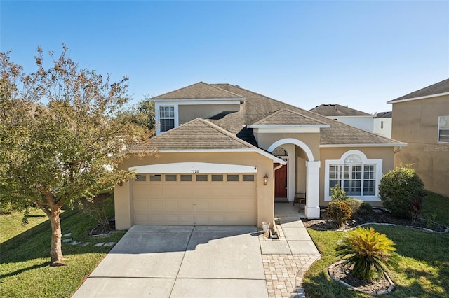 7720 Rathdown Ln, Wesley Chapel, FL 33545 - view of front of house featuring stucco siding, driveway, an attached garage, and a front yard