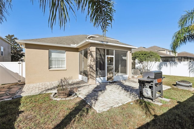 7720 Rathdown Ln, Wesley Chapel, FL 33545 - rear view of property featuring an outdoor fire pit, a sunroom, stucco siding, a fenced backyard, and a patio area