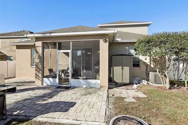 7720 Rathdown Ln, Wesley Chapel, FL 33545 - back of house with a sunroom, a patio area, stucco siding, and roof with shingles