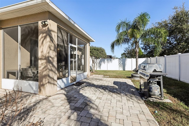 7720 Rathdown Ln, Wesley Chapel, FL 33545 - fenced backyard featuring a sunroom, a grill, and a patio area