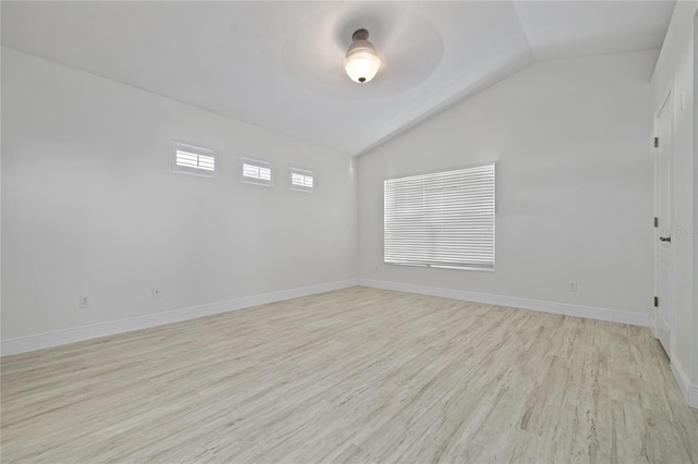 empty room with lofted ceiling, ceiling fan, and light hardwood / wood-style flooring