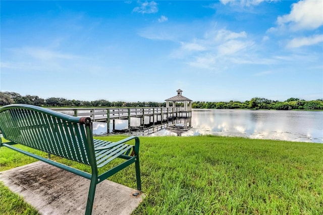 dock area with a lawn, a gazebo, and a water view