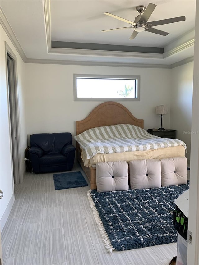 bedroom featuring a raised ceiling, ceiling fan, and ornamental molding