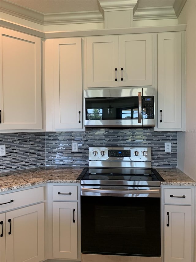 kitchen featuring white cabinetry, crown molding, appliances with stainless steel finishes, and tasteful backsplash