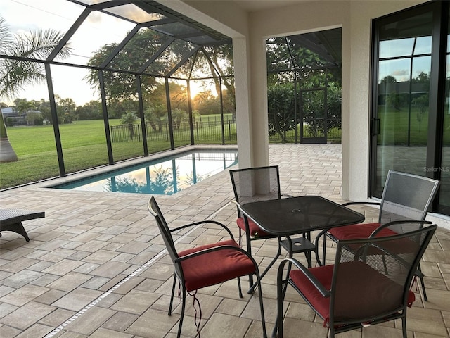 view of swimming pool featuring a lawn, glass enclosure, and a patio