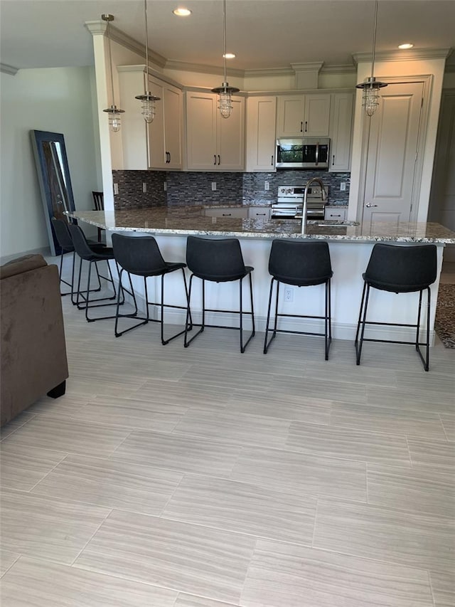 kitchen with stone countertops, kitchen peninsula, hanging light fixtures, and appliances with stainless steel finishes