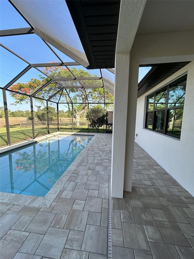 view of swimming pool with a patio and glass enclosure