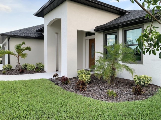 doorway to property with a lawn