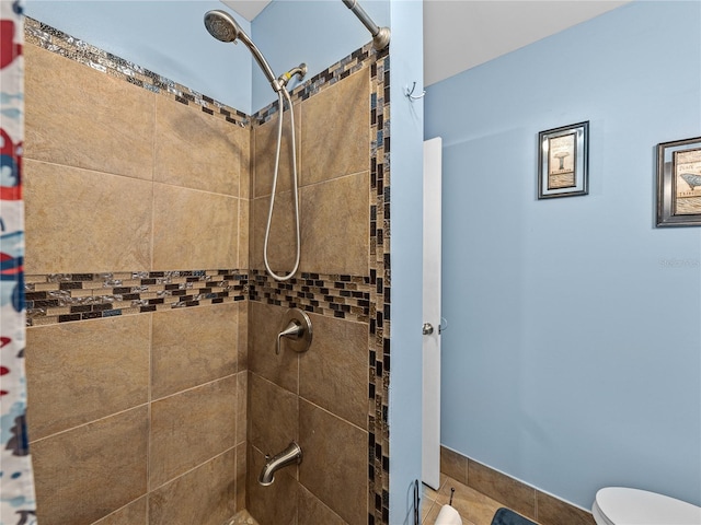 bathroom with toilet and a tile shower