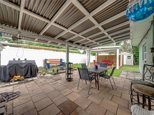 view of patio / terrace with a grill and a shed