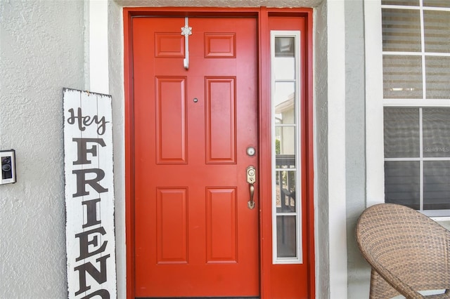 entrance to property featuring stucco siding