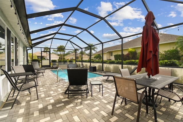 view of pool featuring glass enclosure and a patio