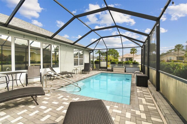 view of pool featuring glass enclosure and a patio