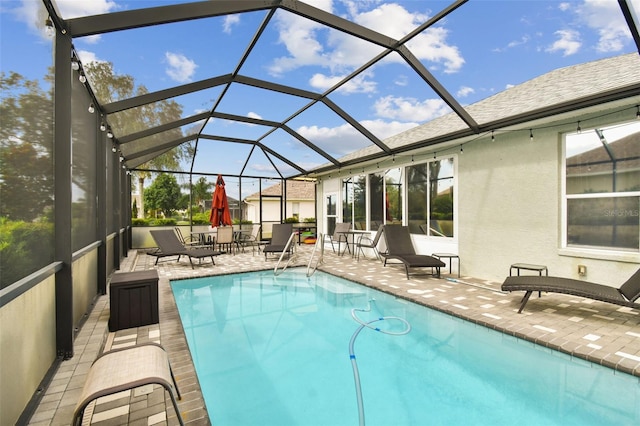 view of swimming pool with a patio and a lanai