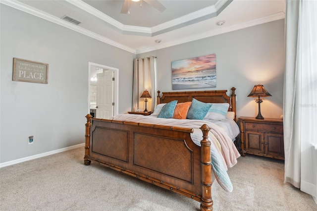 bedroom with ceiling fan, ornamental molding, light colored carpet, and a tray ceiling