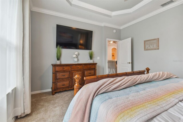 bedroom featuring a raised ceiling, crown molding, and light colored carpet