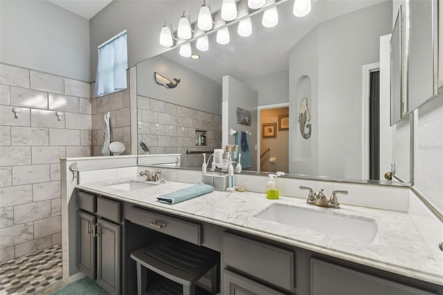 bathroom with double vanity, a walk in shower, tile walls, and a sink