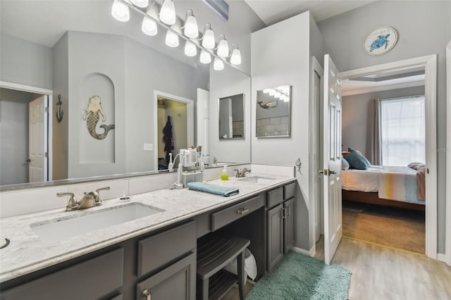 ensuite bathroom featuring double vanity, wood finished floors, ensuite bathroom, and a sink