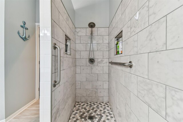 bathroom featuring hardwood / wood-style flooring and a tile shower