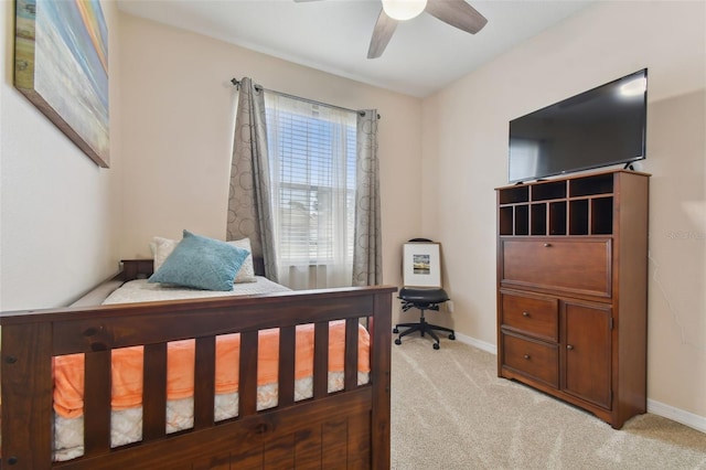 bedroom featuring a ceiling fan, light colored carpet, and baseboards