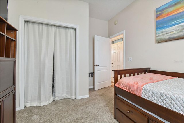 bedroom featuring baseboards and light colored carpet