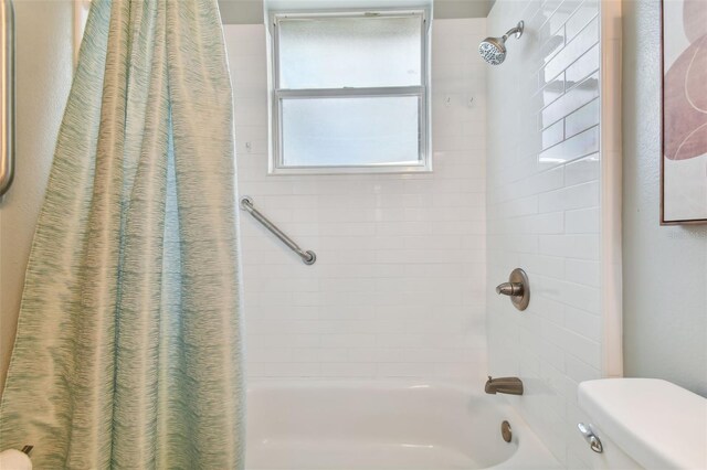 bathroom with shower / tub combo and toilet