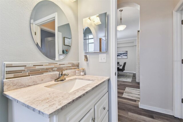 bathroom with backsplash, hardwood / wood-style flooring, and vanity