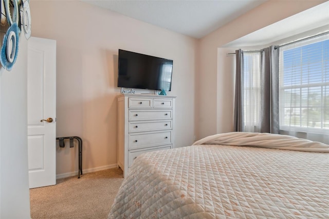 bedroom featuring light carpet and baseboards